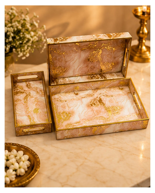 Pink marble-look tray set styled with flowers on a console