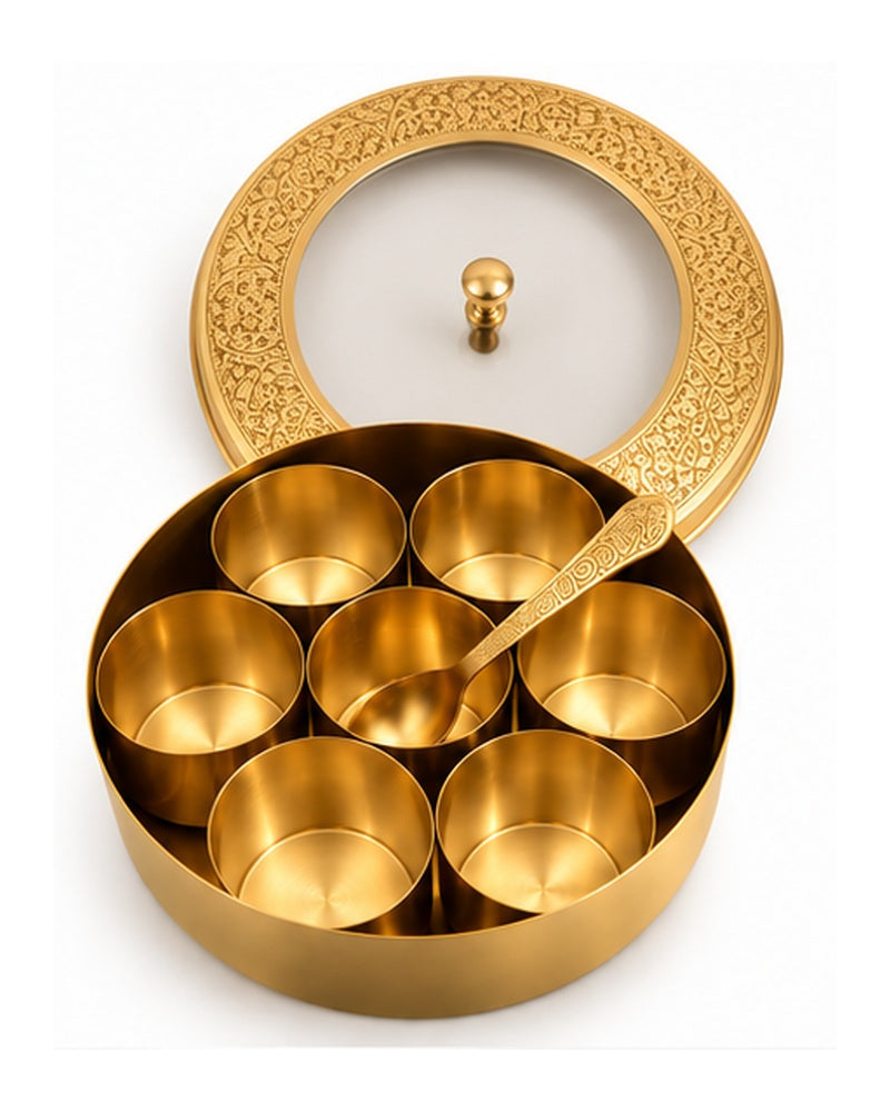 Brass masala dabba open showing seven spice bowls and spoon