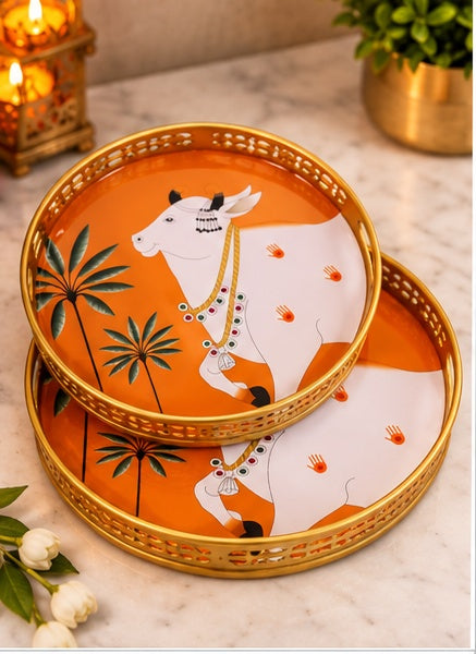 Orange Pichwai cow and palm round trays set of 2, styled in a festive setting